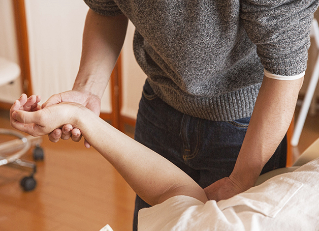 Therapeut bei der Stimulation der Propriozeptoren